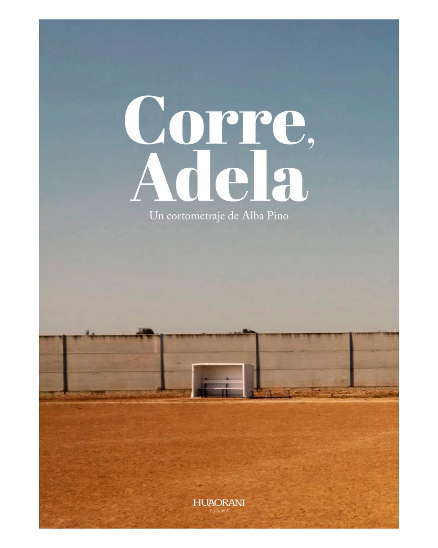Cartel del cortometraje 'Corre, Adela' dirigido por Alba Pino, presentando un campo vacío con el fondo de un muro alto, simbolizando la niñez y aspiraciones en Galicia.